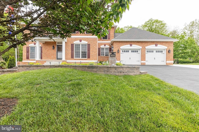 view of front of property with an attached garage, brick siding, and a front lawn