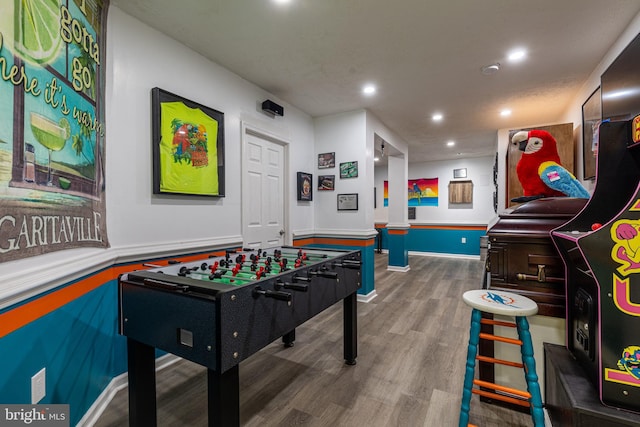 game room featuring wood finished floors, recessed lighting, and a wainscoted wall