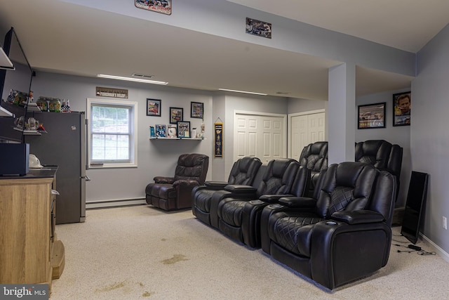 home theater room featuring light carpet, baseboard heating, and baseboards