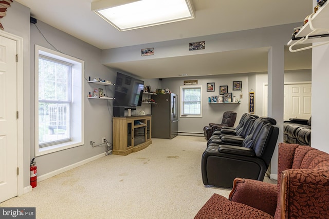 living area with light carpet, baseboards, a fireplace, and a baseboard radiator