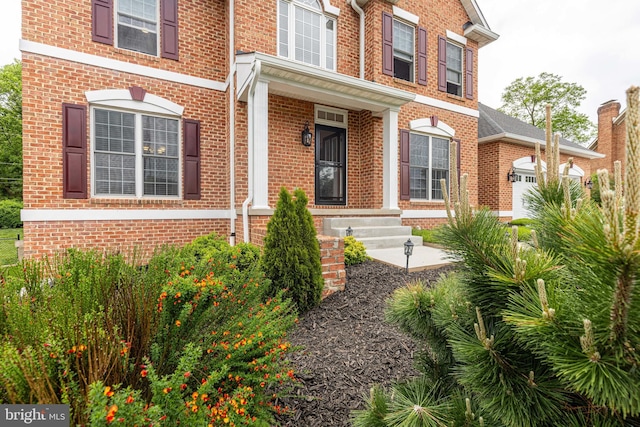 entrance to property with brick siding and an attached garage