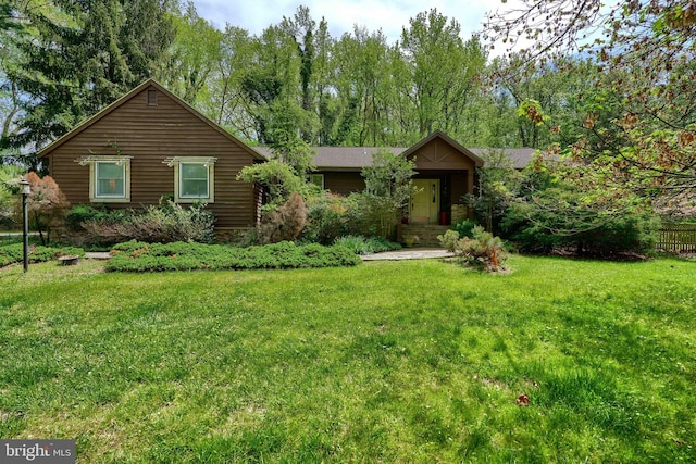 single story home with a front yard and fence