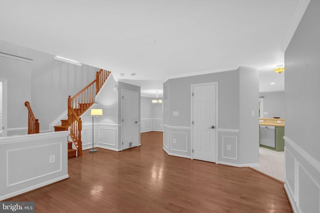 5620 Nutwell Sudley Rd, Deale, MD 20751 - unfurnished living room with a wainscoted wall, ornamental molding, wood finished floors, stairs, and a chandelier