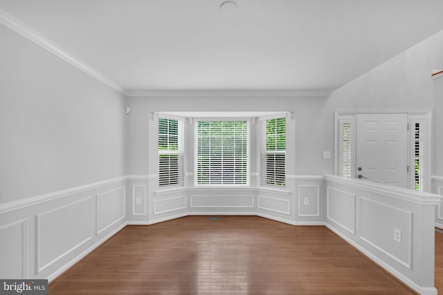 5620 Nutwell Sudley Rd, Deale, MD 20751 - empty room featuring plenty of natural light, hardwood / wood-style flooring, a wainscoted wall, ornamental molding, and a decorative wall