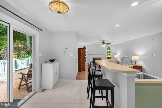 5620 Nutwell Sudley Rd, Deale, MD 20751 - kitchen with ceiling fan, a kitchen breakfast bar, a fireplace, light countertops, and recessed lighting