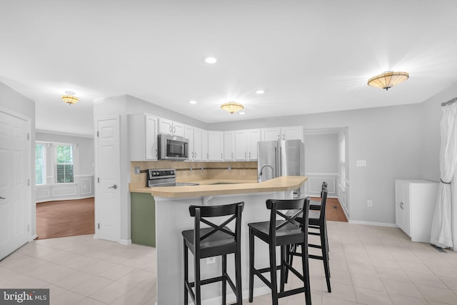 5620 Nutwell Sudley Rd, Deale, MD 20751 - kitchen featuring stainless steel appliances, light countertops, a kitchen bar, recessed lighting, and white cabinetry