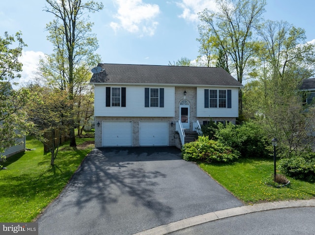 split foyer home with aphalt driveway, a garage, and a front lawn