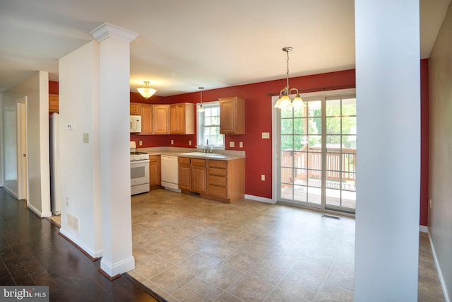 kitchen with white appliances, visible vents, light countertops, hanging light fixtures, and baseboards
