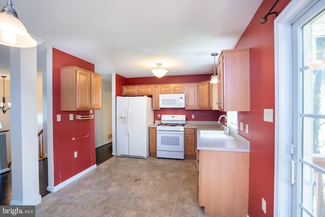 kitchen with light countertops, a wealth of natural light, a sink, and white appliances