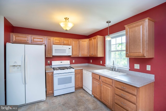 kitchen with white appliances, light countertops, pendant lighting, and a sink