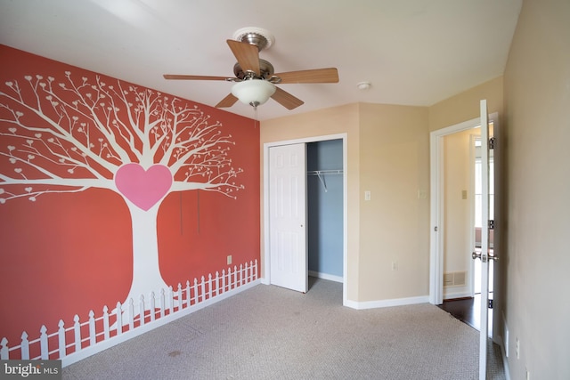 unfurnished bedroom featuring carpet flooring, a closet, visible vents, baseboards, and ceiling fan