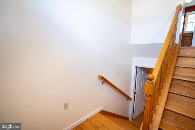 stairway with baseboards and wood finished floors