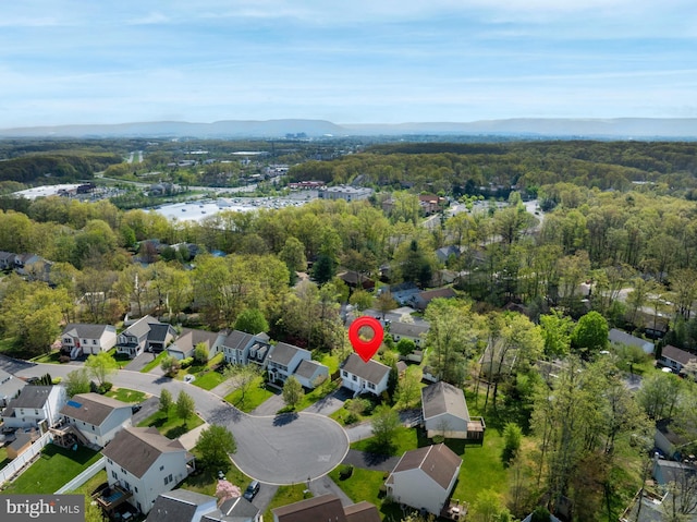 drone / aerial view featuring a forest view, a mountain view, and a residential view