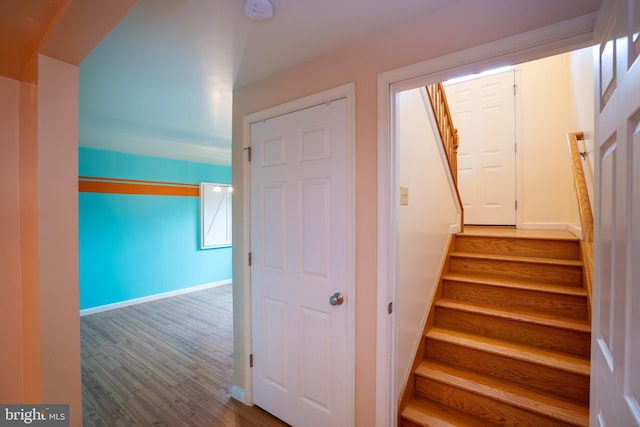 stairs featuring wood finished floors and baseboards