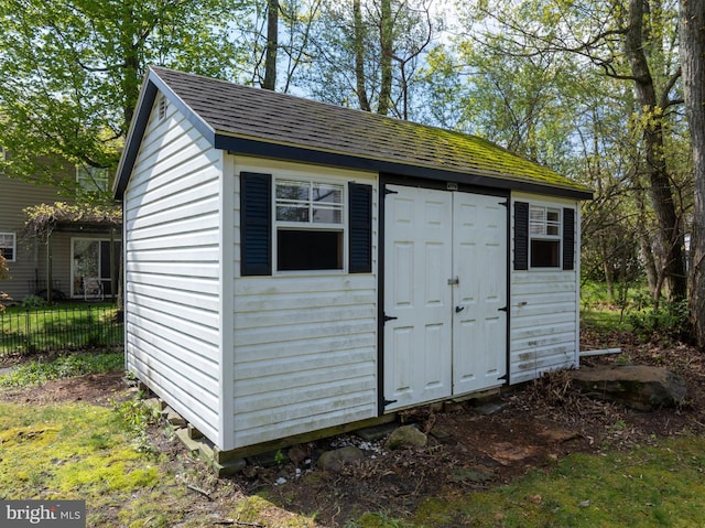 view of shed featuring fence