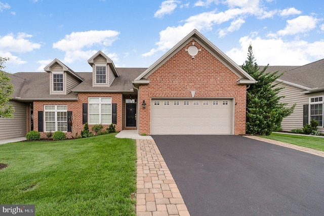 traditional home featuring driveway, brick siding, a front yard, a garage, and a shingled roof