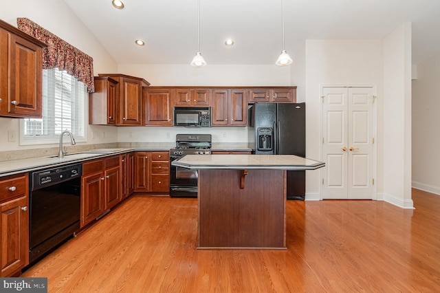 kitchen with black appliances, a sink, light wood-style floors, light countertops, and recessed lighting