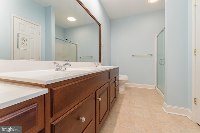 bathroom with a stall shower, baseboards, double vanity, tile patterned flooring, and toilet