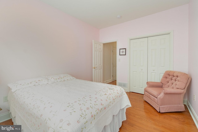 bedroom featuring light wood-style floors, a closet, and baseboards