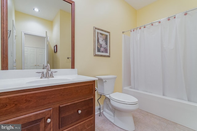 bathroom featuring toilet, tile patterned floors, vanity, shower / bath combo with shower curtain, and baseboards