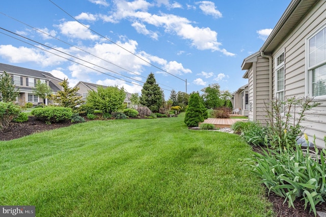 view of grassy yard with a wooden deck