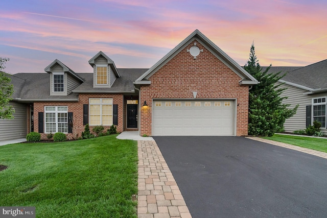 traditional-style home with asphalt driveway, brick siding, an attached garage, and a front yard