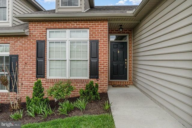 property entrance with brick siding and roof with shingles