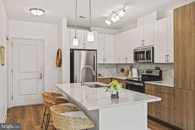 10755 Fairgrounds Dr Unit 320, Fairfax, VA 22030 - kitchen with stainless steel appliances, a sink, a center island with sink, dark wood-type flooring, and backsplash