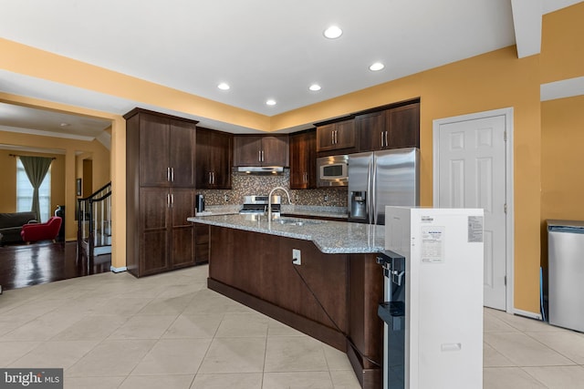 42496 Legacy Park Dr, Brambleton, VA 20148 - kitchen with stainless steel appliances, tasteful backsplash, light tile patterned floors, dark brown cabinets, and light stone countertops