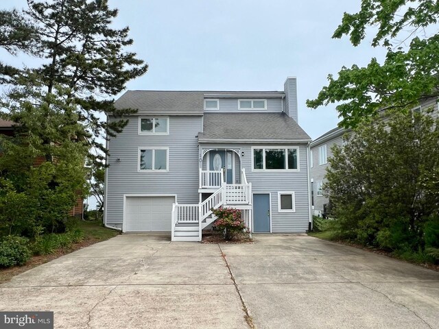 10 Riverside Ct, Ocean Pines, MD 21811 - coastal inspired home with roof with shingles, stairs, an attached garage, driveway, and a chimney
