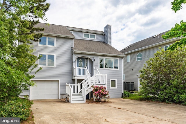 10 Riverside Ct, Ocean Pines, MD 21811 - view of front of property featuring central air condition unit, a chimney, a garage, concrete driveway, and a shingled roof