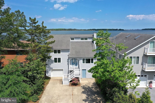 10 Riverside Ct, Ocean Pines, MD 21811 - view of front of house featuring roof with shingles, an attached garage, driveway, and a chimney