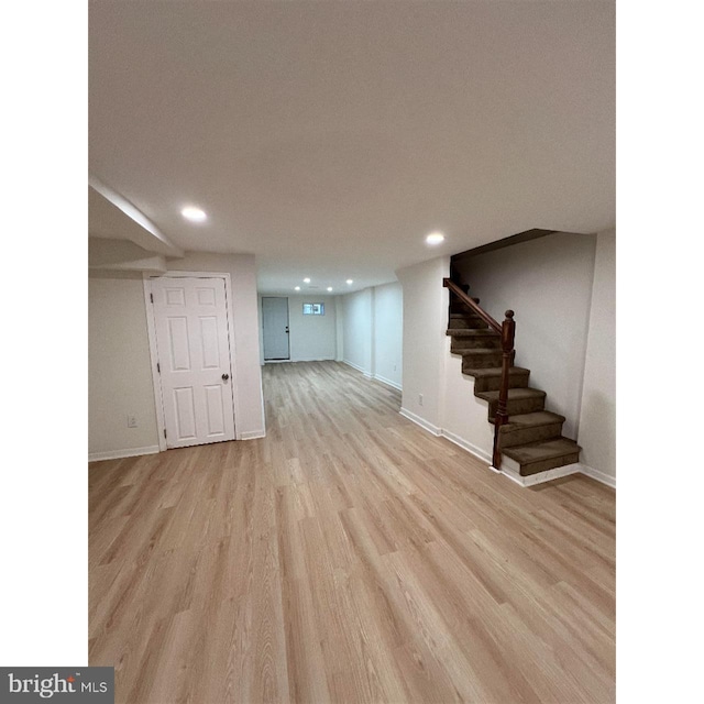 finished below grade area with stairway, wood finished floors, baseboards, and recessed lighting