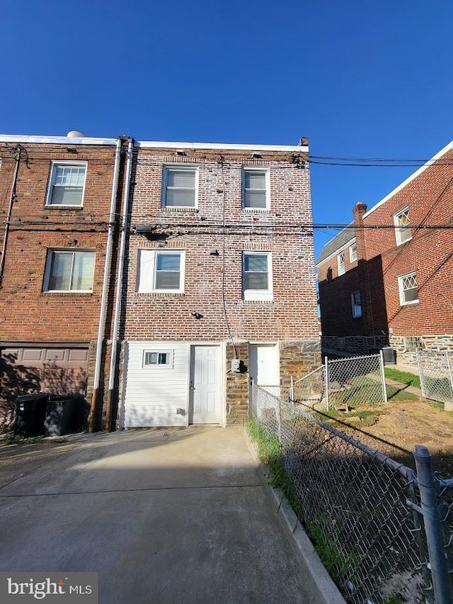 rear view of property with fence and brick siding