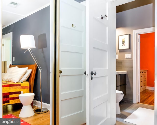 bathroom featuring toilet, visible vents, and wood finished floors
