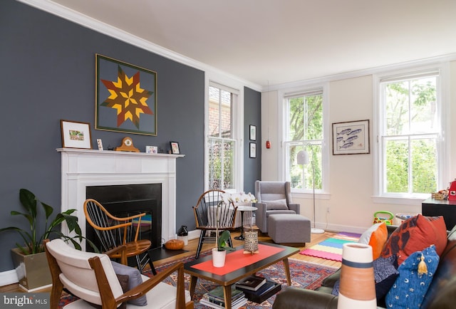 living area featuring crown molding, baseboards, a fireplace with flush hearth, and wood finished floors