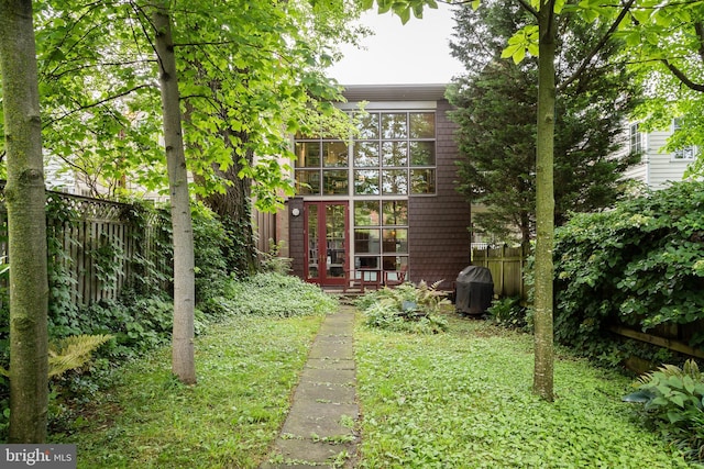 view of yard featuring french doors and fence