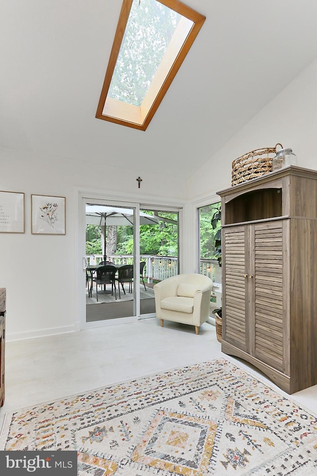 living area with plenty of natural light, a skylight, and lofted ceiling
