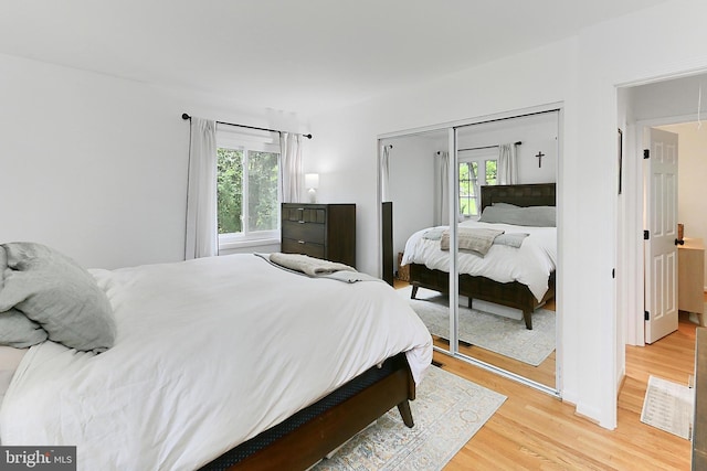 bedroom with light wood-style flooring and a closet