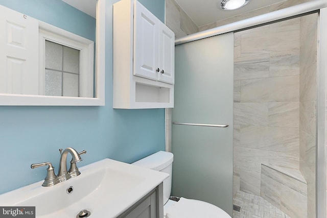 bathroom featuring a stall shower, toilet, and vanity