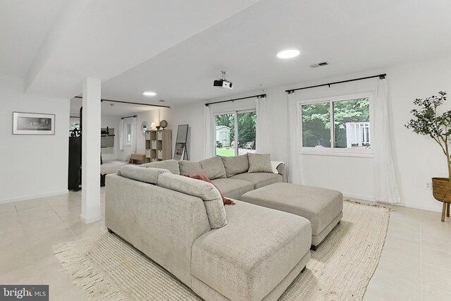 living room featuring light tile patterned floors, baseboards, and recessed lighting