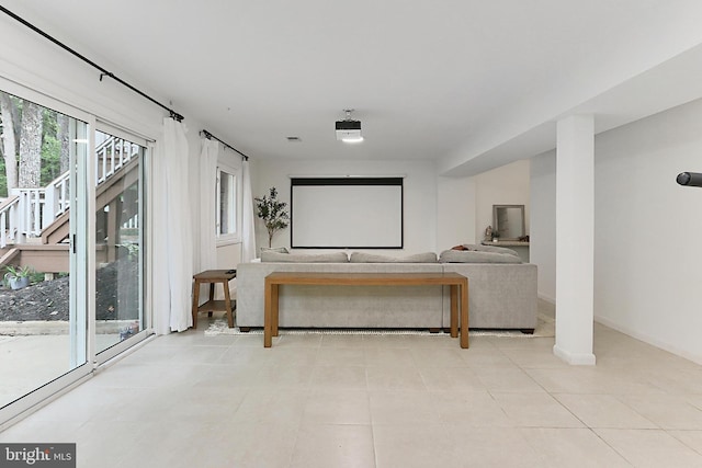 home theater room featuring light tile patterned floors and baseboards