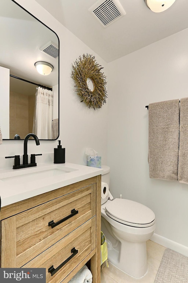 bathroom with tile patterned flooring, toilet, vanity, and baseboards