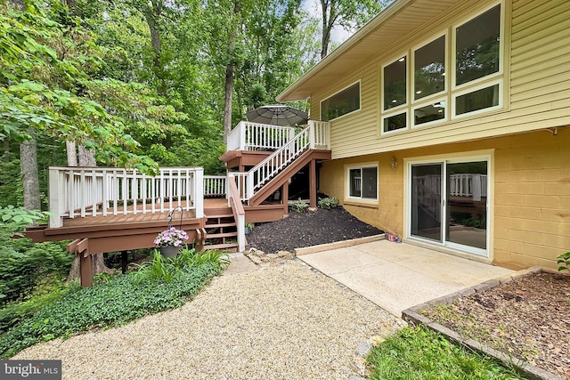 back of property with stairway, a wooden deck, and a patio