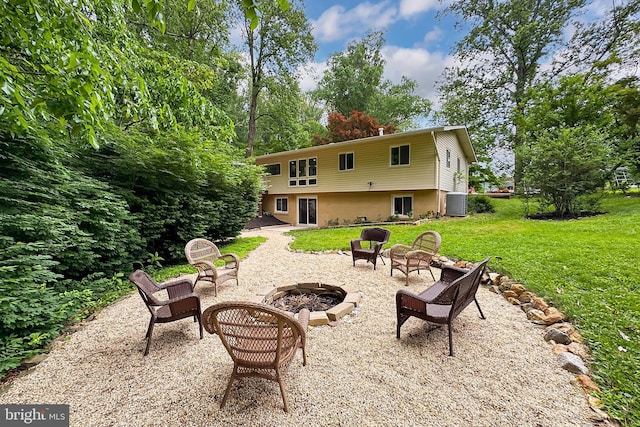 back of house with an outdoor fire pit, a lawn, central AC, and a patio area