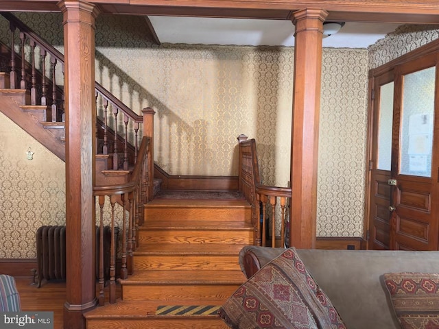 911 E King St, Lancaster, PA 17602 - staircase featuring wallpapered walls, radiator heating unit, decorative columns, wood finished floors, and baseboards