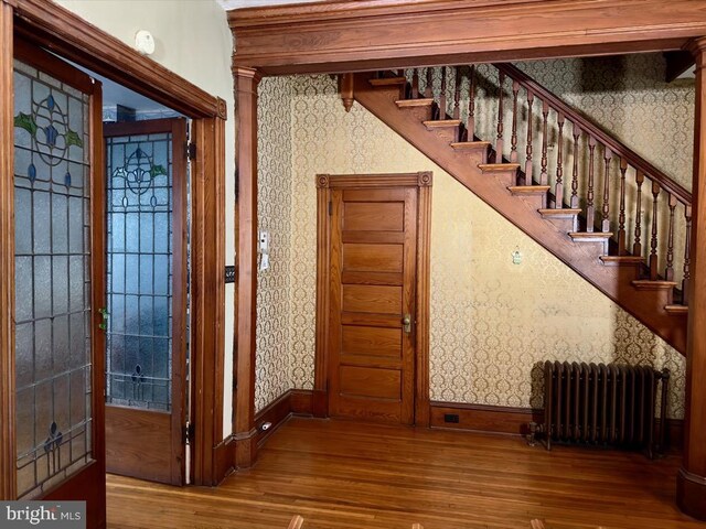 911 E King St, Lancaster, PA 17602 - stairs featuring radiator, wallpapered walls, wood finished floors, and baseboards