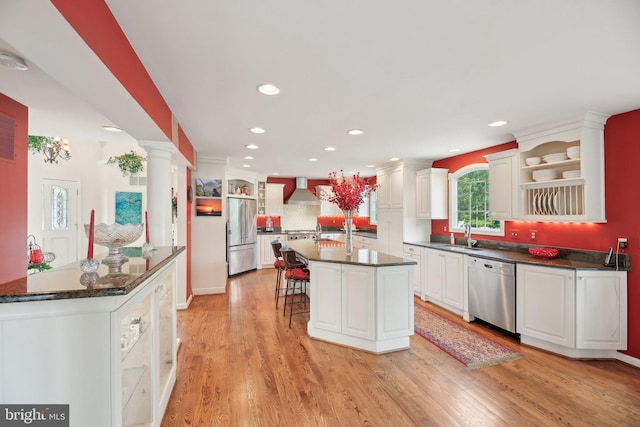 kitchen with appliances with stainless steel finishes, open shelves, a sink, a kitchen breakfast bar, and recessed lighting