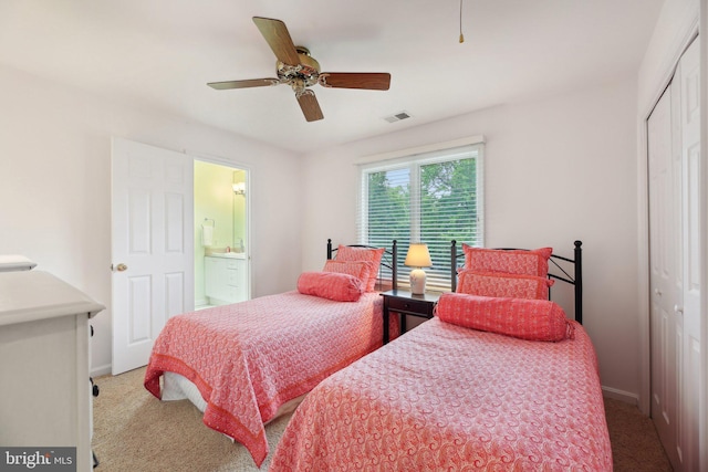 carpeted bedroom featuring a closet, baseboards, ceiling fan, and ensuite bathroom