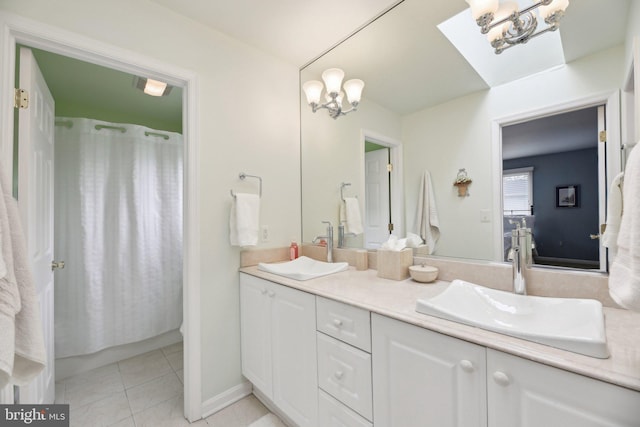 full bath with double vanity, curtained shower, a skylight, tile patterned floors, and a chandelier